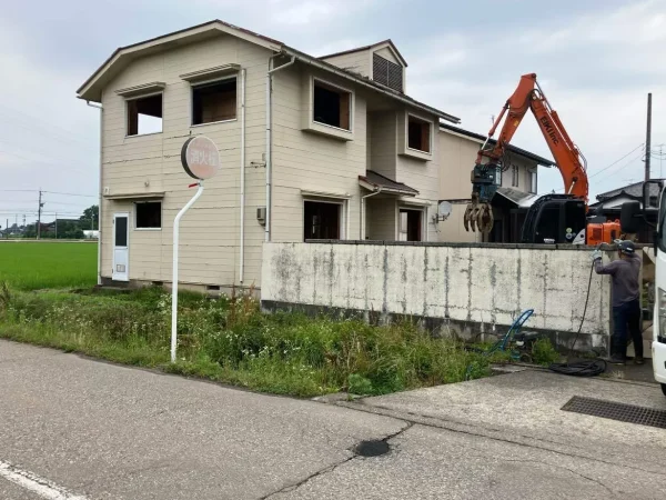 すでに内部解体を終えた住宅の外部解体を、弊社エイキの油圧ショベルを使って解体しています。窓枠がすでに撤去されています。これから解体していきます。
