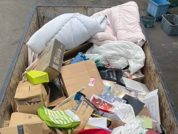 解体工事の着工前に回収された、お客様の不用品（布団・段ボール・生活用品）。富山の解体業者エイキでは、家財道具の仕分けから適切に処分・リサイクルをサポートしています。