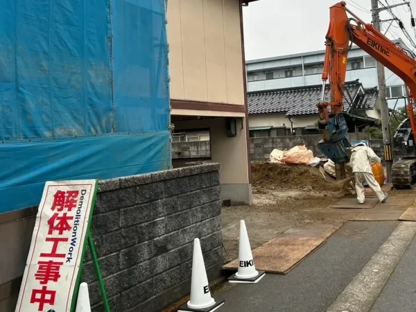 富山市の木造2階建て解体工事現場。「解体工事中」と書かれてある注意看板が敷地内のブロック塀の前に置かれている
