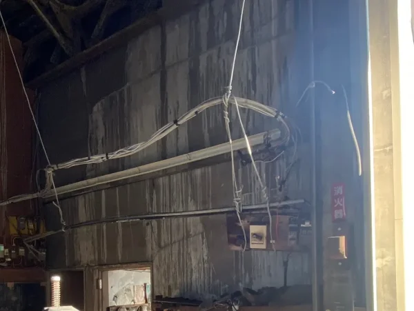 富山のモルタル壁解体工事の現場。　壁に配線や細い管がついている状態