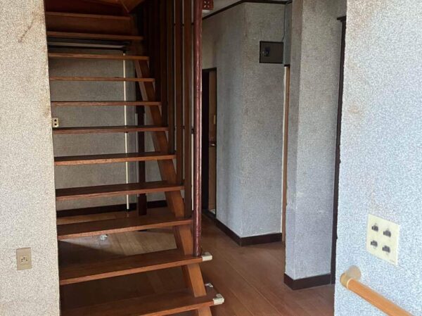 富山市北部の解体前の木造２階建ての住宅。室内の廊下と階段の写真。屋内の不用品を全て外へ運び出した状態 