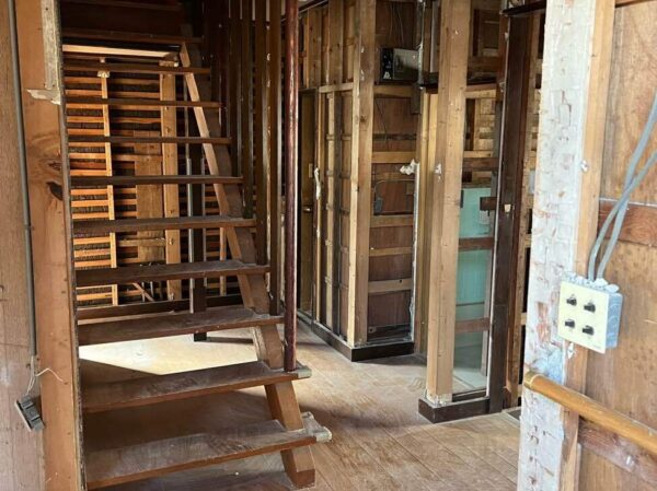 富山市北部の木造２階建ての住宅。内装解体後の室内写真。剥がされた壁材の奥には、立派な柱が見えている。