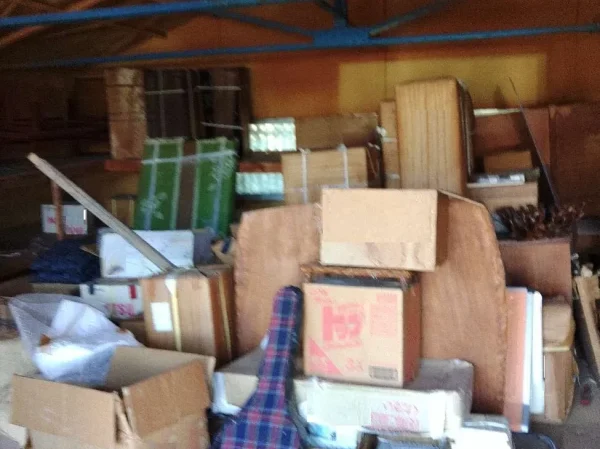 解体前のプレハブ内部。段ボールや楽器ケースが山積みですが、エイキなら中身の回収から丸ごとお引き受けします。