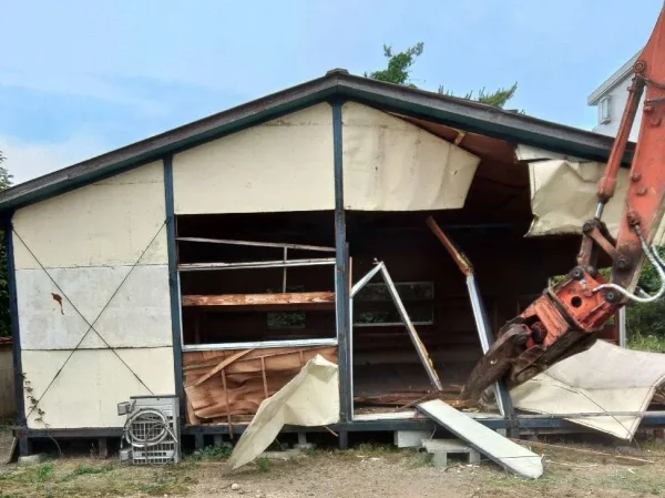 重機を使って壁面を解体する様子。周囲に破片が飛ばないよう気を付けながら重機を操作しました。