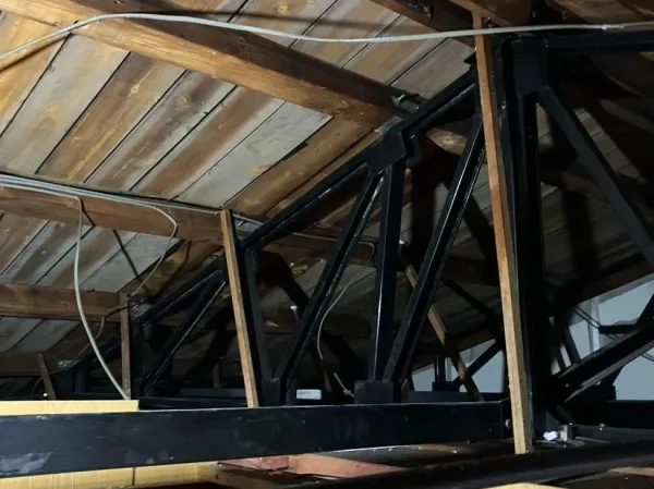 天井裏に現れた軽量鉄骨のトラス。黒い鉄製フレームが屋根を支えているのが分かります。