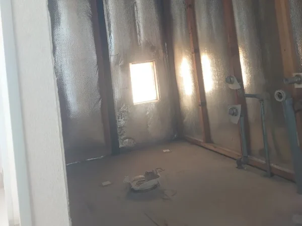 富山で内装解体工事。お風呂場の浴槽やタイルを全て撤去し、配管と断熱材が残っている状態