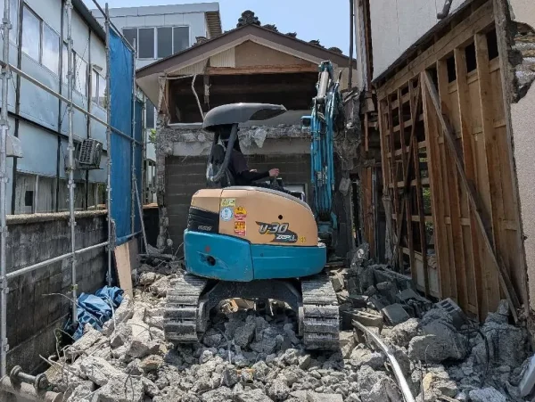 狭いスペースでも自在に動く小型重機。お隣の壁や塀を傷つけないよう、繊細なレバー操作で進めます。