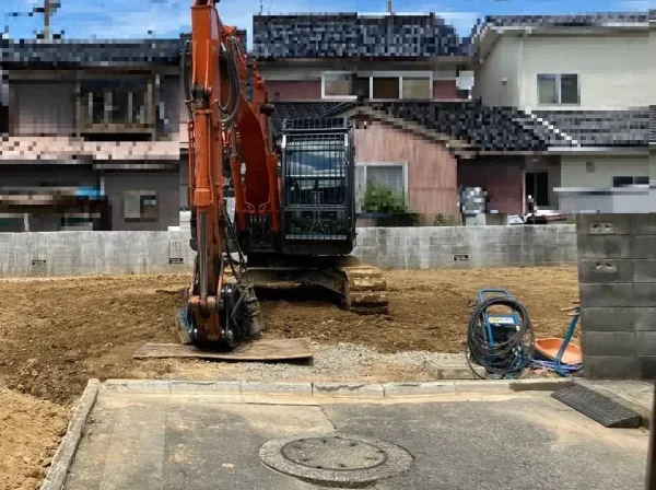 更地の写真。仕事をやり終えた油圧ショベルが更地の上に静かに佇んでいます。
