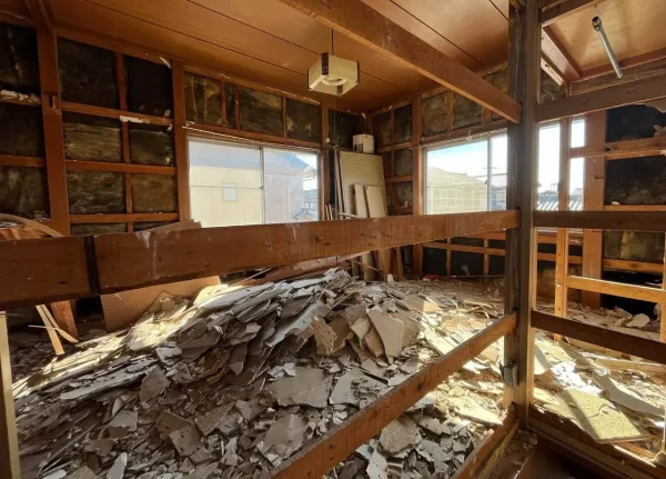 剥がされた壁材と断熱材。それらを撤去する前の写真。