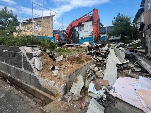 油圧ショベルが、解体廃棄物を材質ごとにまとめている。