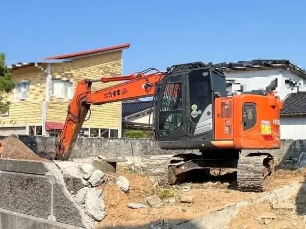 油圧ショベルが基礎コンクリートを解体している。