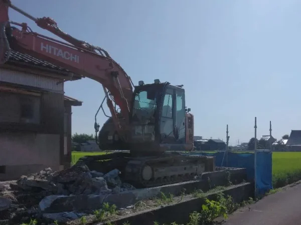 重機、油圧ショベルで、基礎コンクリートを解体撤去している。