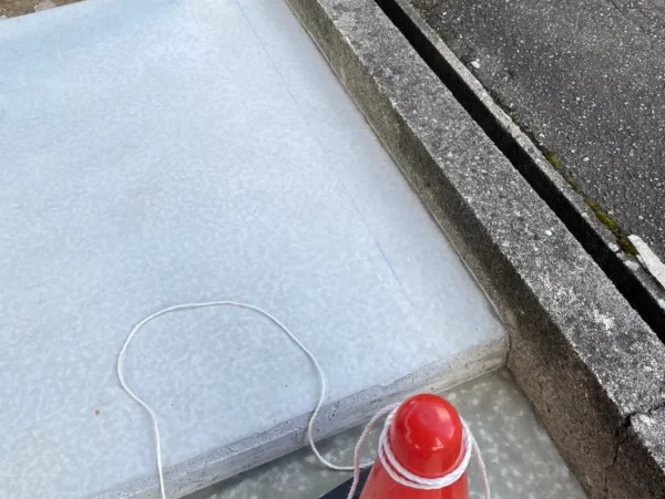 富山県内で水路新設斫り工事。解体工事前の土間と赤色のカラーコーンが写っている