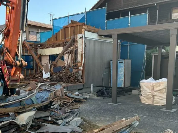 隣家と解体する住宅との間には養生。カーポートと住宅との距離はわずかしかない。