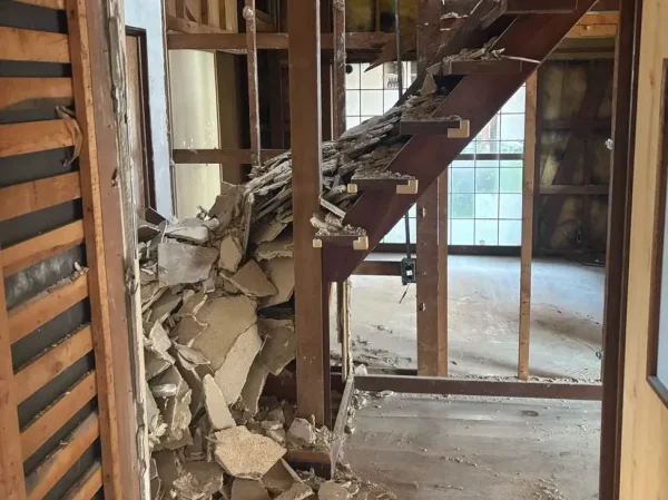 解体中の屋内の様子。階段周辺で解体された断熱材や石膏ボードが写っている。