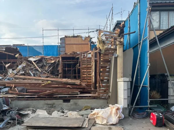 屋外の様子。躯体が解体されつつある。隣の家との間には、青色の養生がなされている。