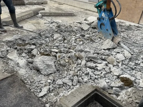 重機のアタッチメントを、のみのような形をした「ブレーカー」に付け替えて、コンクリートに振動を与えて細かく砕いている写真