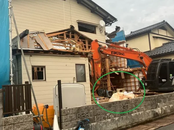 内部解体を終え、構造体（躯体）を重機で解体しています。 手前にフレコンバッグが写っています。