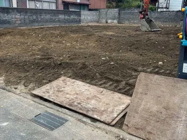 住宅本体を解体し終え、更地つくりをしている。右側の重機は転圧中。