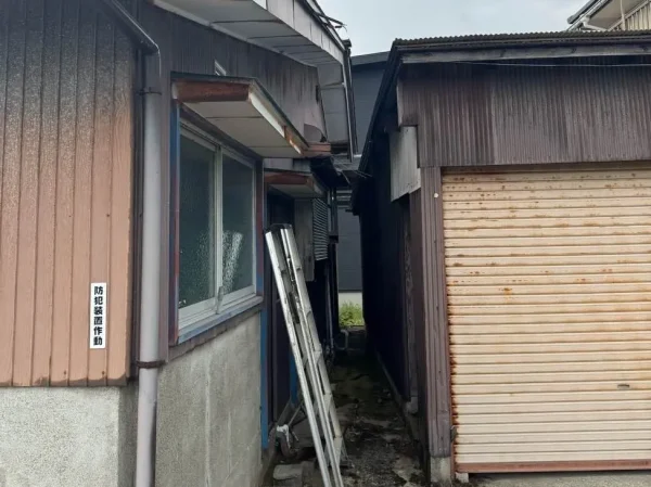 左の住居と右の車庫の間が１メートルも離れていないことが分かる写真。