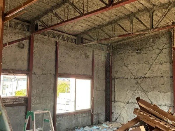 住宅の壁を撤去すると現れてきた内部の鉄骨梁。床には脚立と木造の廃材がある