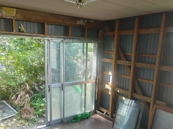窓ガラスが外され、これから撤去するサッシの一部にヒビが入った窓枠付近の様子。壁はすでに撤去されている