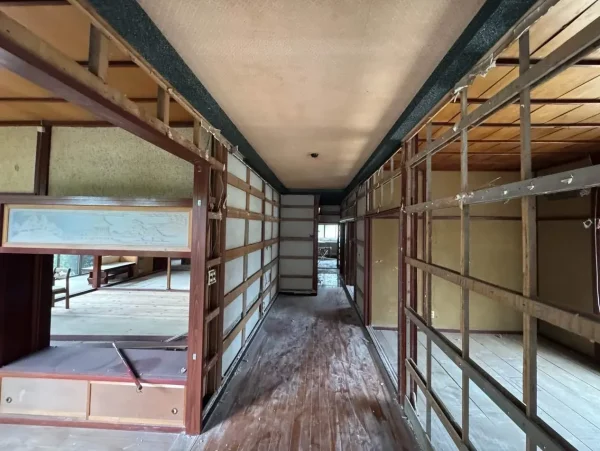 内部解体の写真。廊下を挟んで、壁が剥がされ、柱や梁が剥き出しになっている。