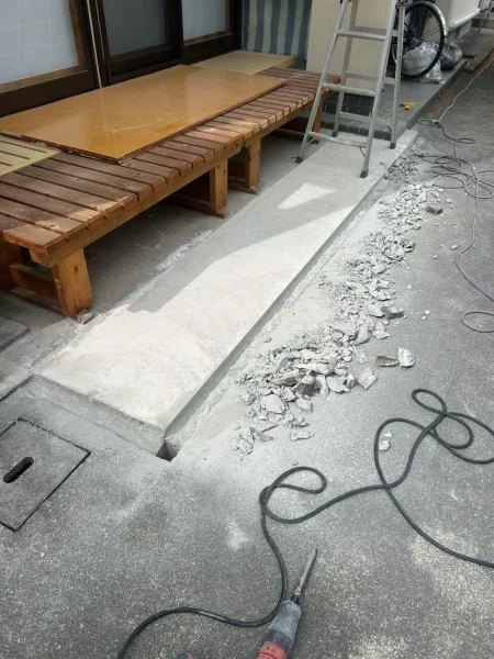 電動工具と削られた（斫られた）コンクリート。手前に工具と斫られたコンクリートのガラ。