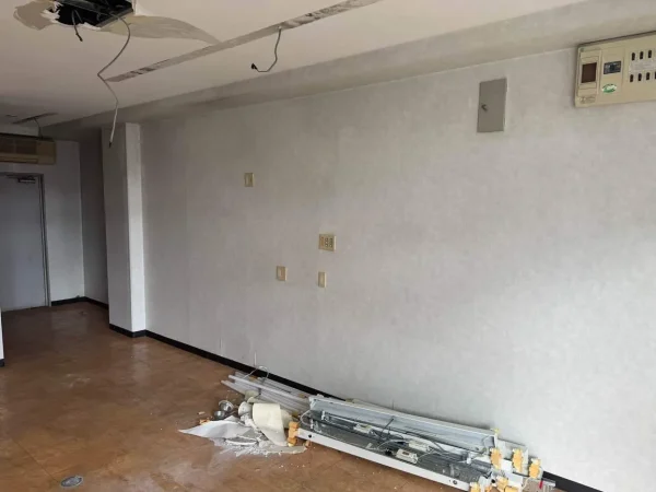 天井と壁から照明や電気系統が外され、荷物がまとめられている写真