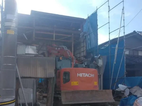 住宅の構造を屋外から、重機で解体している。
