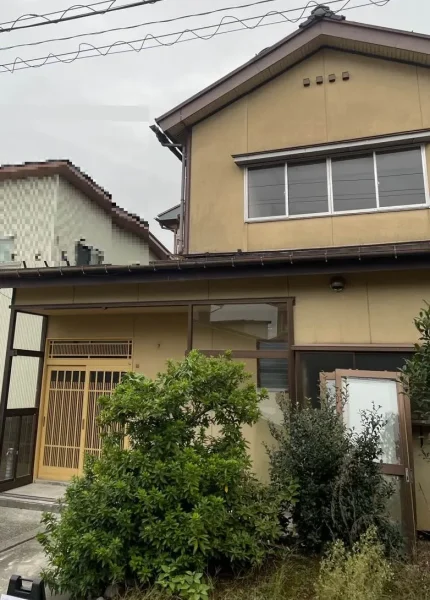 解体前の住宅の様子。前庭には植栽。左側には隣家が見える。