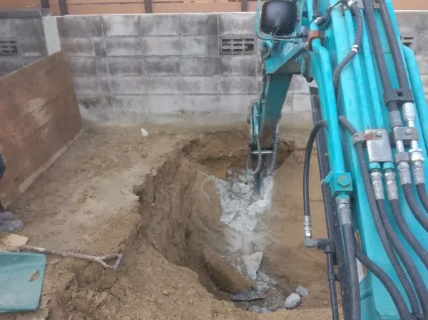 写真の右側にユンボ。アームについてアタッチメントで土を確認している。