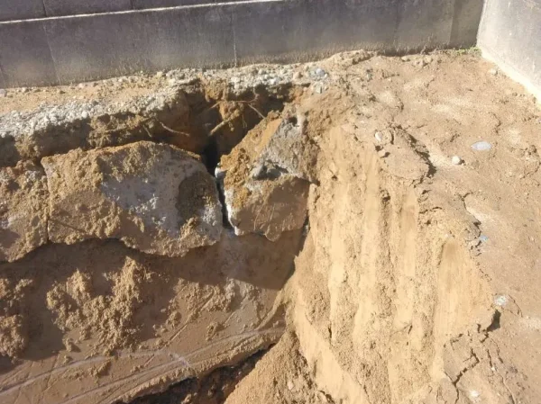 コンクリート塀の脇からコンクリートガラが見えている。