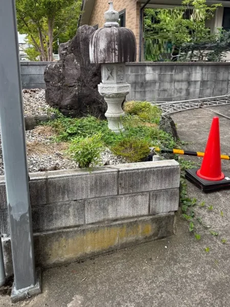大きな庭石と灯籠が並んでいる写真。右には赤いコーンが見える。
