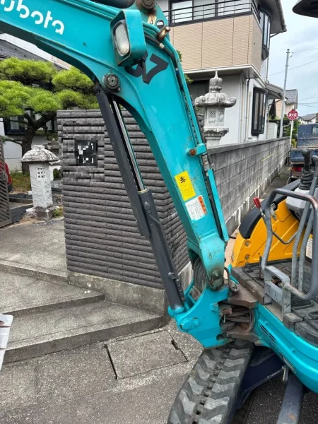 現場に搬入する青い重機（油圧ショベル）の写真。