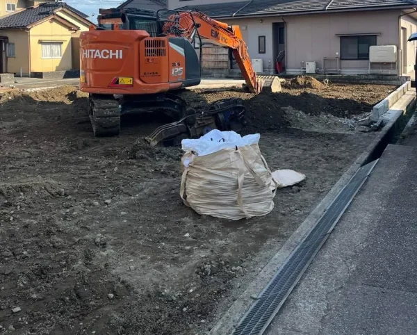 基礎を撤去した後の地面を整えている重機の姿。