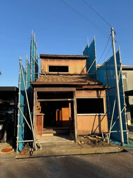 今回の現場。これから解体する住宅は、左右の家との間隔がなく、住宅と隣の家との間に青色シートで養生している。