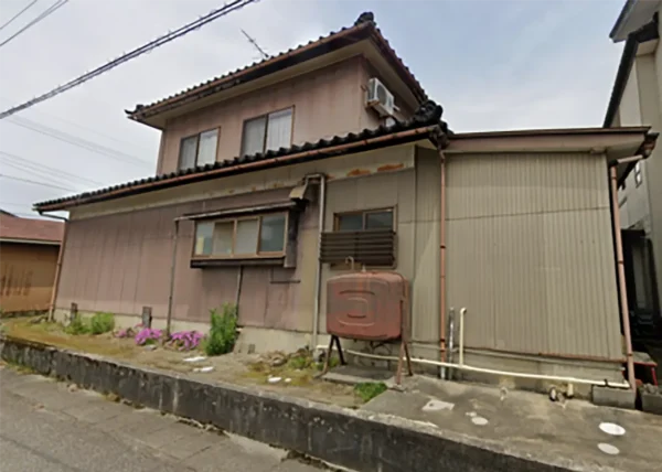 今回の解体現場の写真です。木造2階建て住宅。建物の周囲には、背の低い植栽が見えます。