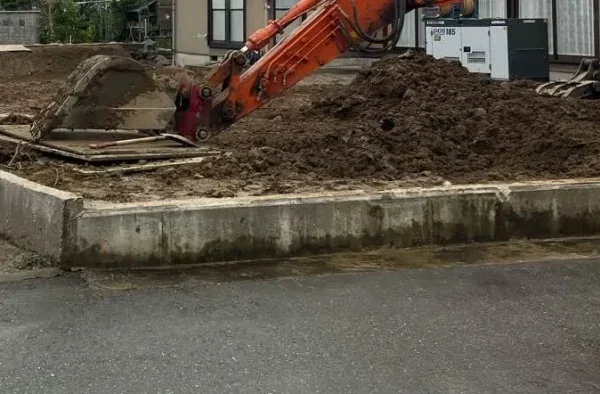 地中の大きなもの（石や根っこ）を取り除いた後、その他の小さな不要物を撤去している写真