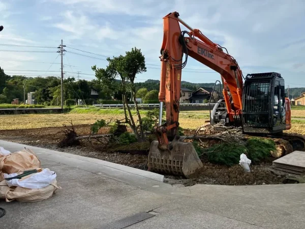 納屋を撤去した後、油圧ショベルを用い、植栽も撤去している。