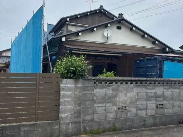 住宅倍にある今回の現場写真。コンクリート塀と養生シートが見える。