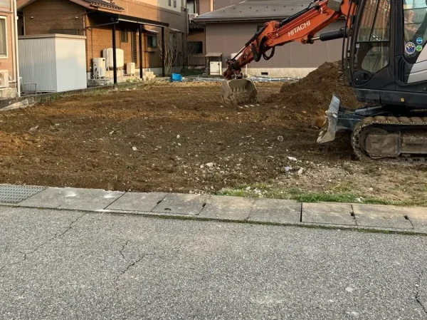 カーポートを解体撤去したのち、敷地を油圧ショベルで均等にならしている。