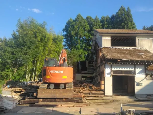 いよいよ重機が入る。写真の右側には、これから躯体を壊す予定の住宅、左側には、重機が写っている。