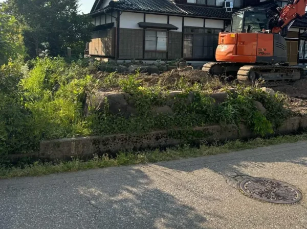 生垣の土台にあたる庭石を撤去中。手前に前道が見える。