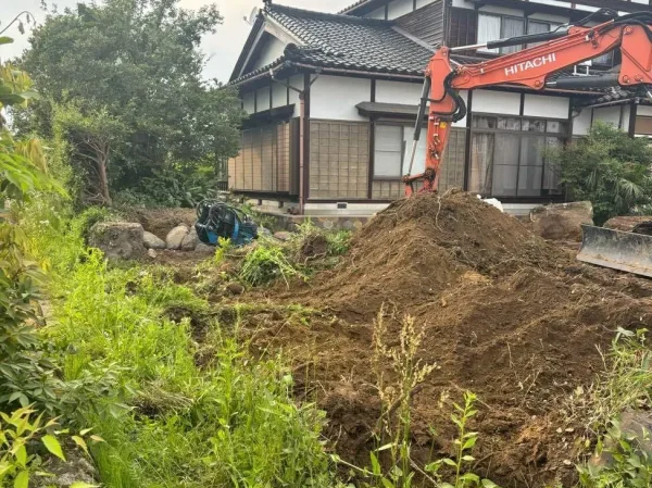 油圧ショベルで植栽の根っこを伐根中。