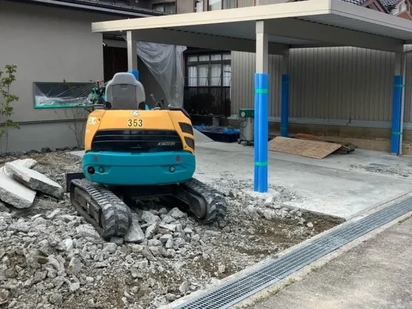 小さな重機の写真。手前の土間を剥がしている。
