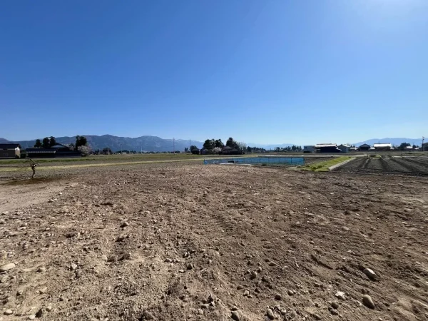 住宅を解体し、基礎も解体。スッキリとした更地となった。遠くに山が見える。
