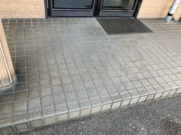 正方形のグレーのタイルが敷き詰められている。これを解体していく（斫っていく）。