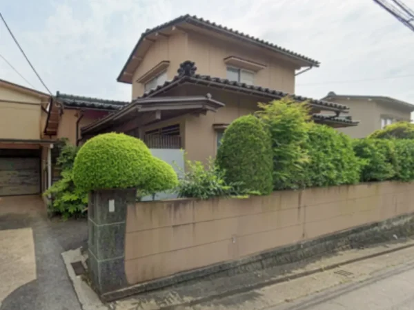 今回解体する木造住宅。庭木と塀に囲まれている。