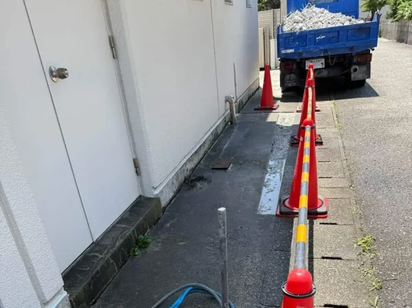 ブロック塀の斫りが完成。奥に青色のトラックが見えるが、荷台には、斫りで出たコンクリートが積まれている。